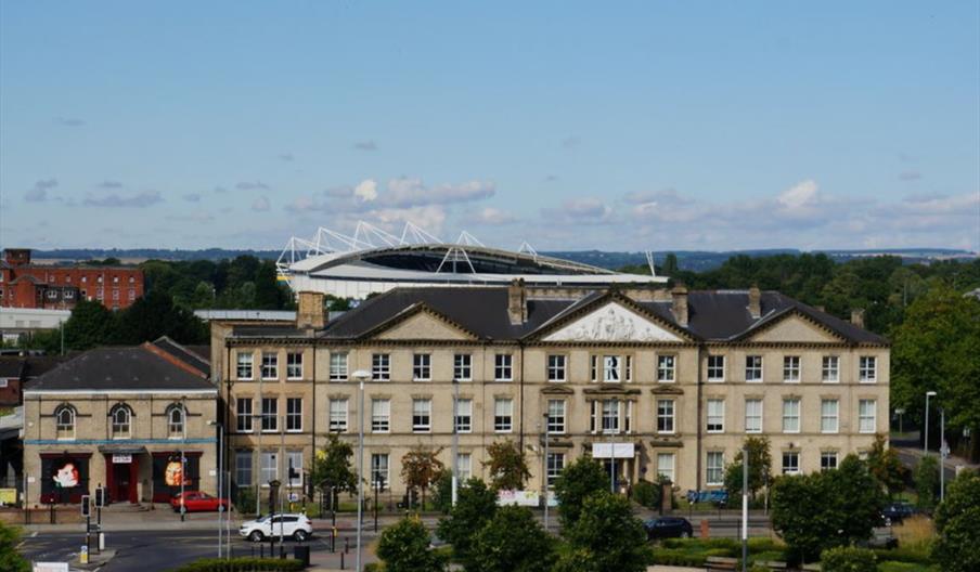 Elevated view of building showing MKM Stadium in the background.