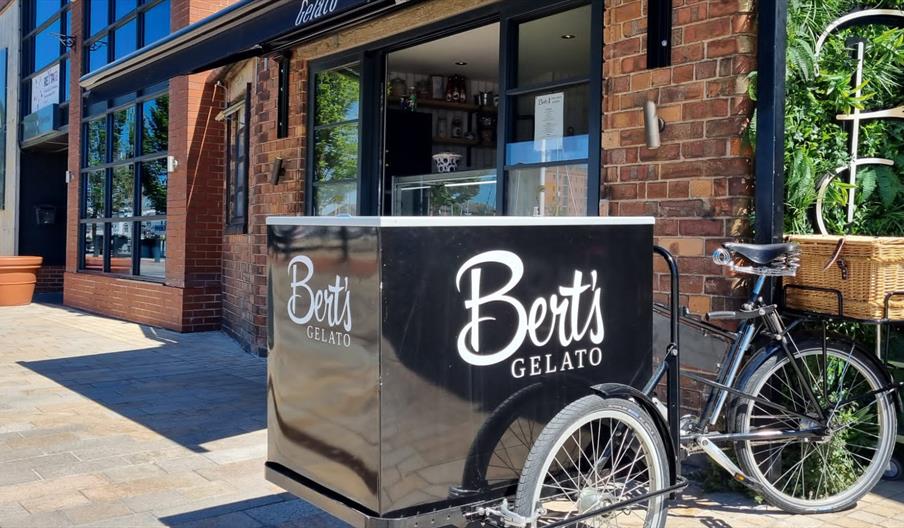 Exterior of Bert's Gelato in Hull's Fruit Market area, featuring a branded gelato bicycle cart parked outside the shop. The modern brick-fronted café
