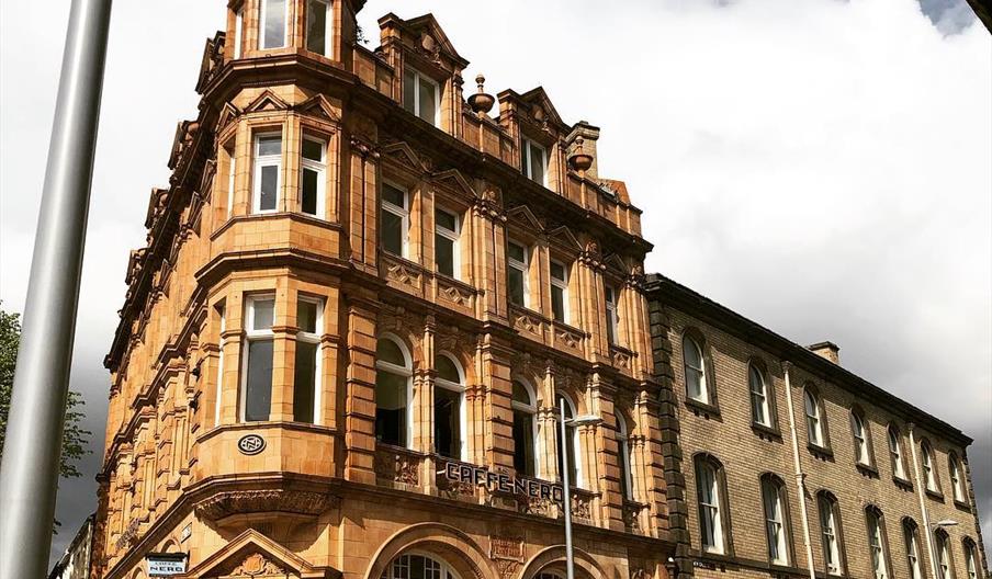 Exterior of a Victorian former bank building on a corner of a busy city centre pedestrian area.
