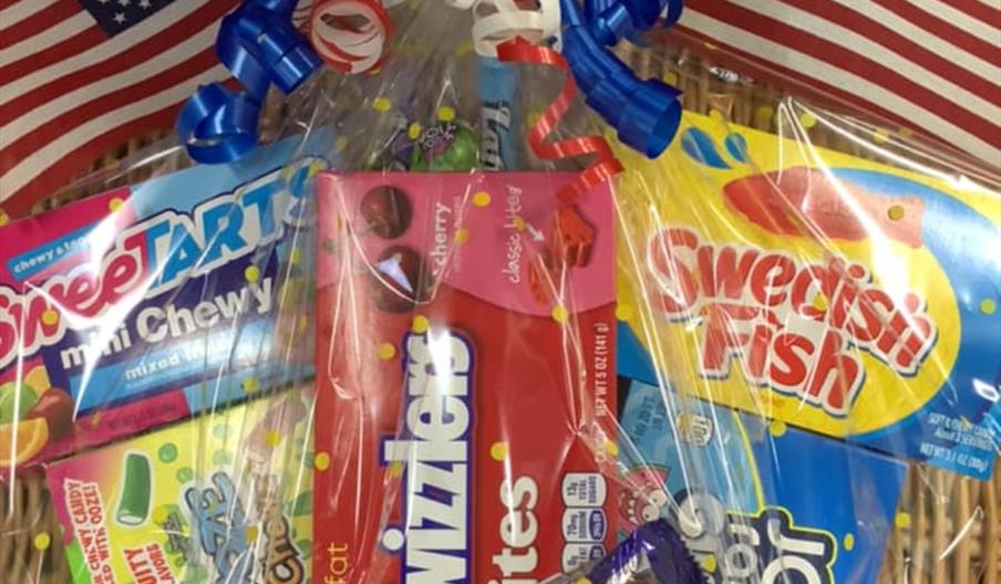 A hamper of american sweets, including swedish fish, jolly ranchers, twizzlers, sweet tarts and bazooka bubble gum.
