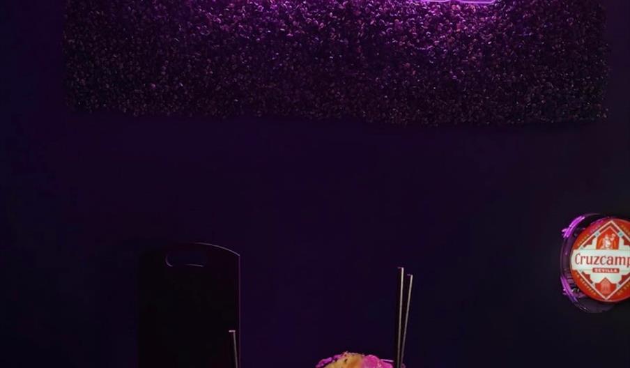 A rainbow coloured circle on a black background, with rainbow text on the inside that reads 'Unit 49'.