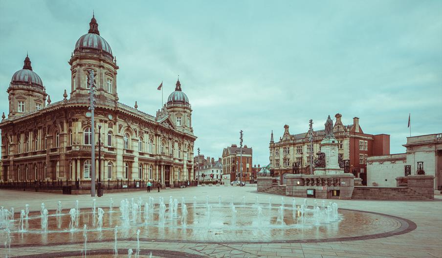Hull's Queen Victoria Square, including the Maritiime Museum, Ferens Art Gallery, the Statue of Queen Victoria in the background. In front, several wa