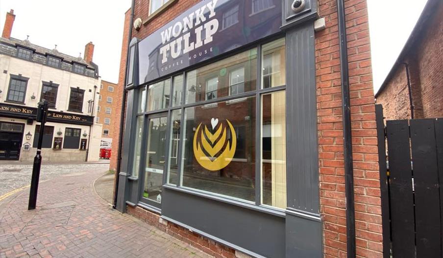 Two blue Wok and Go branded takeout boxes filled with stir fry and noodles on a wooden table.