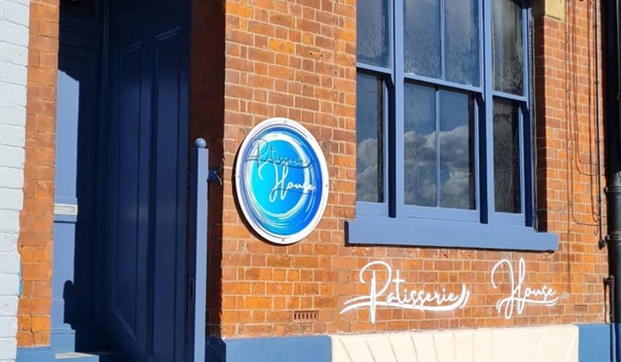 Red brick exterior with 5 steps, leading to a blue painted door.