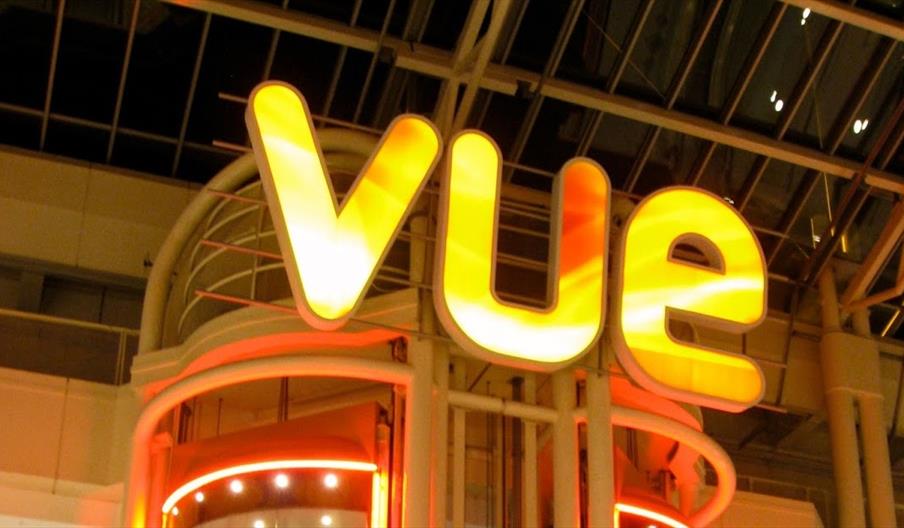 The word 'Vue' in neon lights at the top of a lift shaft.