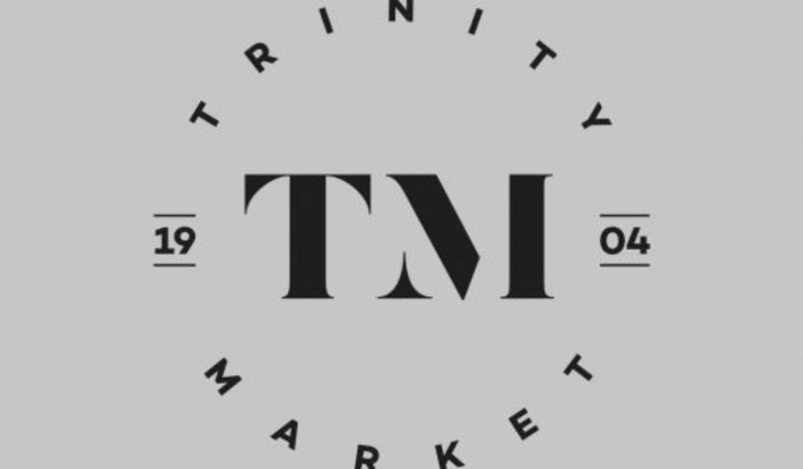 A minimalist logo with the large letters "TM" in the center, encircled by the words "TRINITY MARKET" and the numbers "1904" split on either side of th