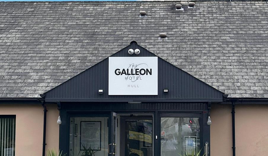 Main entrance showing pointed canopy and hotel sign.