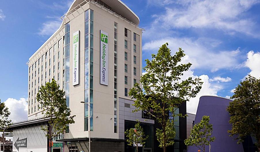 Main entrance to hotel showing sign with Holiday Inn logo in green.