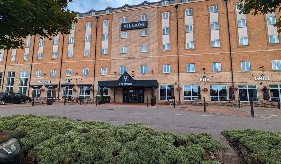 Ouside of hotel with black canopy over main entrance.