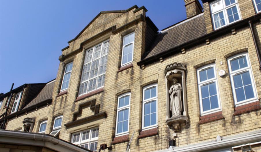 Exterior image showing upper level of buidling with statue.