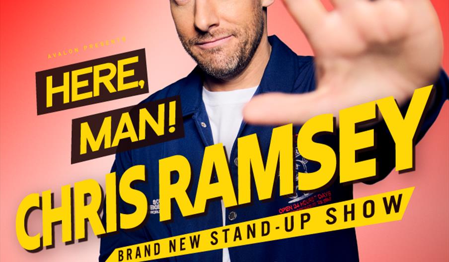 A man with short brown hair and a beard stands against a red background, holding one hand up toward the camera. Bold yellow text on the image reads, "