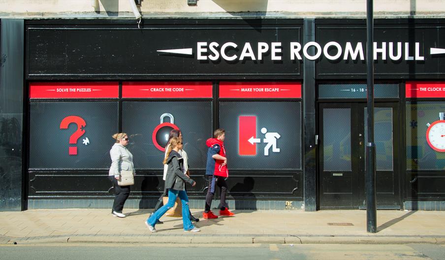 A picture of the outside entrance of the building displaying the name people going inside.
