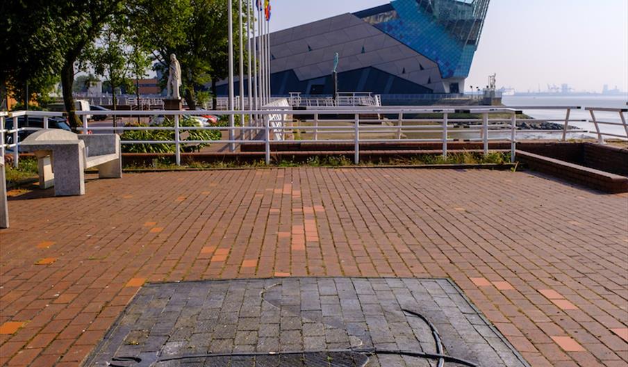 A large mantaray image is embedded into the floor with brickwork around it and The Deep off in the distance behind it.