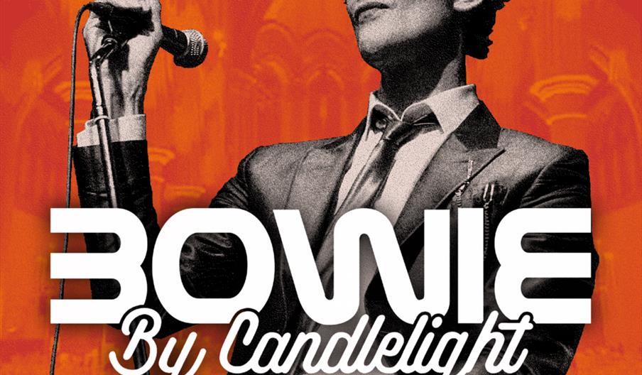 A black and white image of a person in a suit holding a microphone stands against an orange background with stylized arches. Bold text in front reads