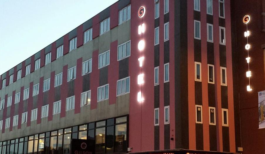 Exterior image of hotel, floodlit at night