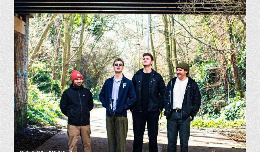 Four men stand under a bridge in a wooded area, posing for a photo. Bold orange text at the top reads "GAWLD," and below the image, black text announc