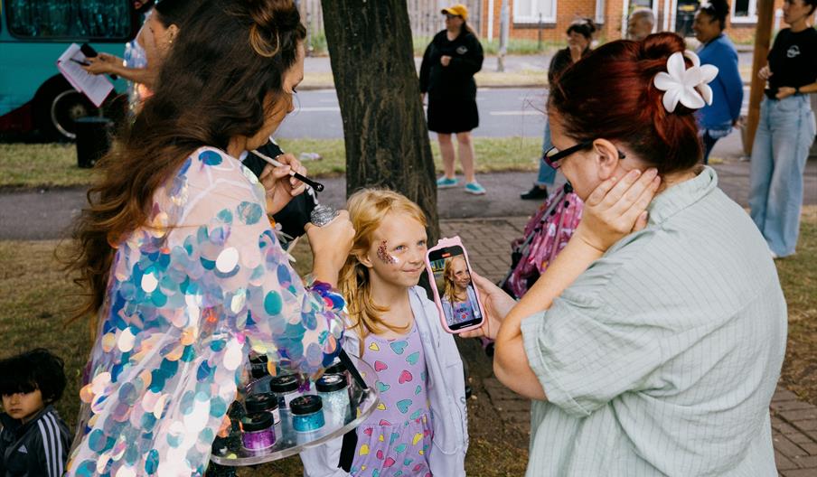 a lady painting a little girls face