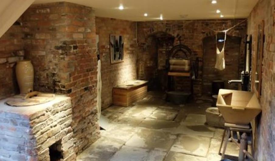 Interior of the Hands On History Museum, where the walls are old brick and various archaic items line the walls.