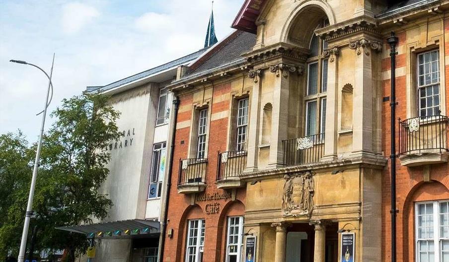 The exterior of Hull Central Library, a red brick and sandstone building with ornate decorations around the windows.