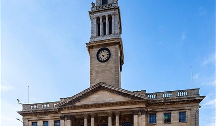 Hull Guildhall a large neoclassical building with a prominent clock tower rising above its entrance, featuring tall columns and arched windows, set ag