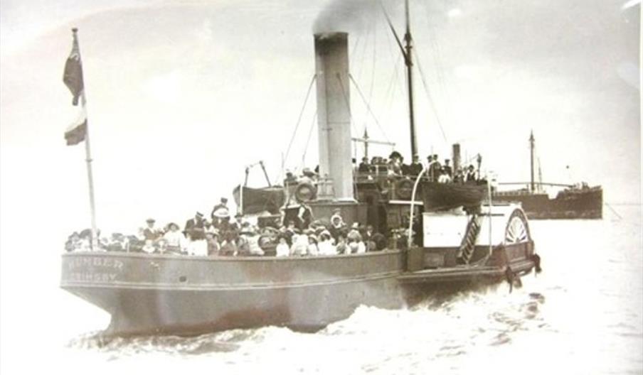Old black and white photograph of a crowded paddle steamer boat on the water, with passengers wearing early 20th-century clothing and hats; another sh