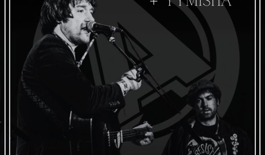 A grayscale event poster features a man holding a microphone on stage. Bold red text at the top reads "Mike Watts" and across the center "Buckfast Tra