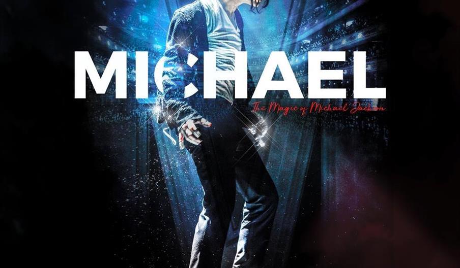 A performer in a sequined jacket, fedora, and white socks strikes a classic dance pose under dramatic stage lighting, with the large word "MICHAEL" an