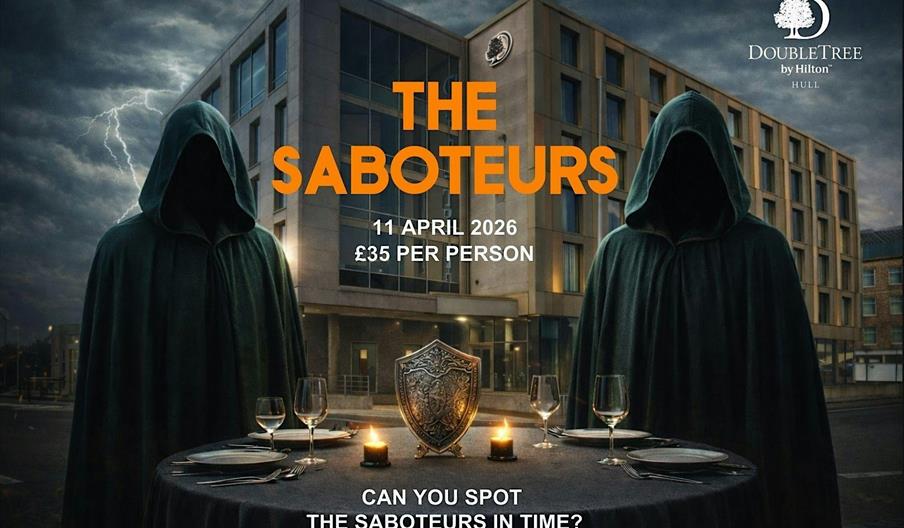 Two hooded, faceless figures in dark cloaks stand on either side of a round dinner table set with candles, glasses, and a decorative shield, with a mo