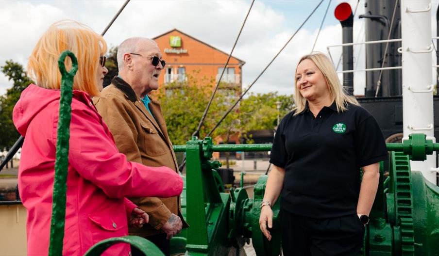 Guided tour on board the Spurn Lightship. 2 people are listening to information on the deck.