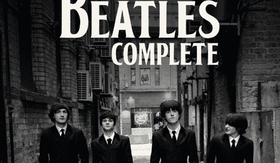 A black-and-white promotional image showing four young men in suits walking down an alley, with large text above them reading "Direct from their Caver