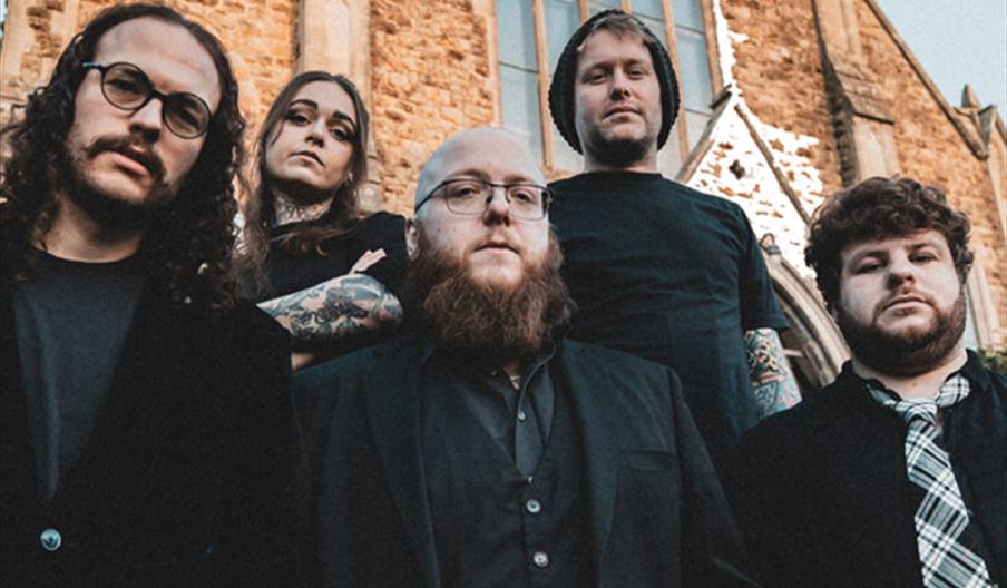 Promotional poster for a Black Water County concert, showing the five band members standing in front of a stone church building, with event details be
