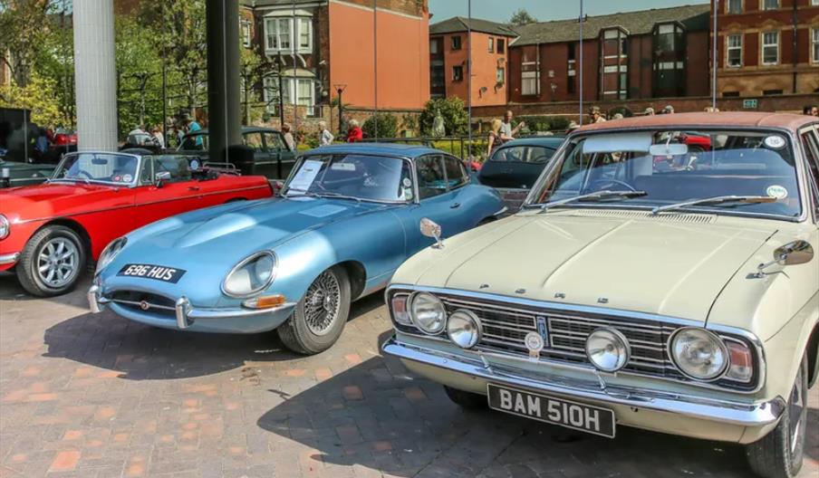 Several classic cars parked.