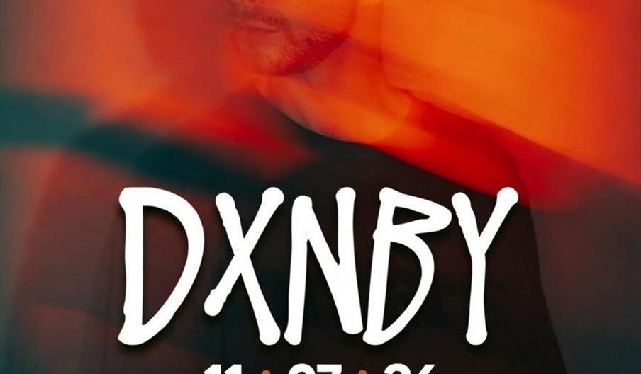 A promotional poster for an event with a blurred, red-tinted image of a man in the background. Large white text in the center reads "DXNBY," with the