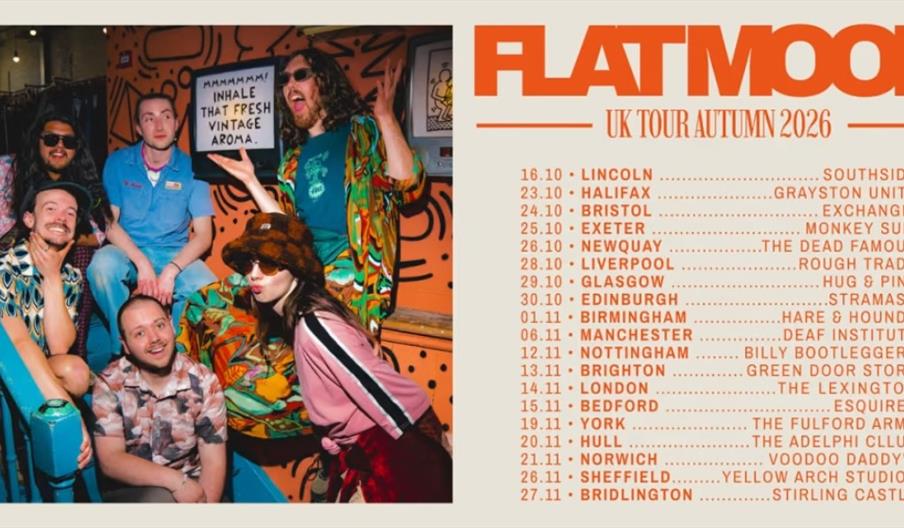 A group of six people pose together on colorful stairs next to a sign that reads "Mmmmmm! Inhale that fresh vintage aroma." On the right, tour dates a