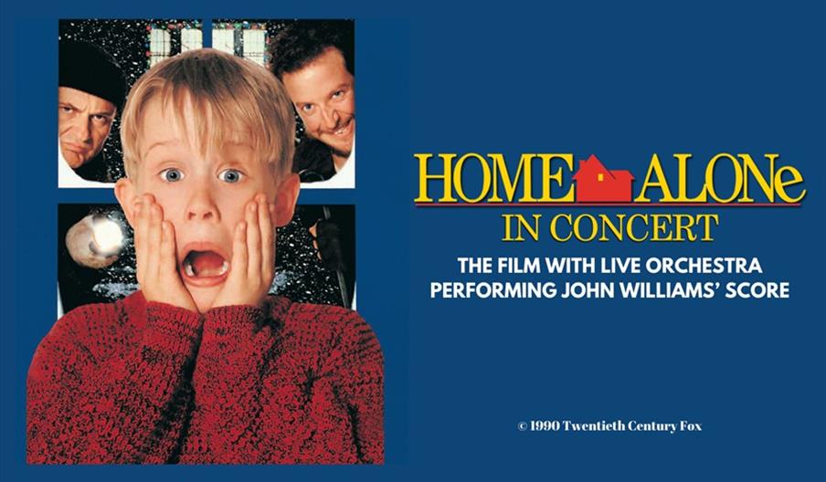 Promotional image for "Home Alone In Concert" showing a surprised boy in a red sweater with hands on his face, two men in the background, and text ann