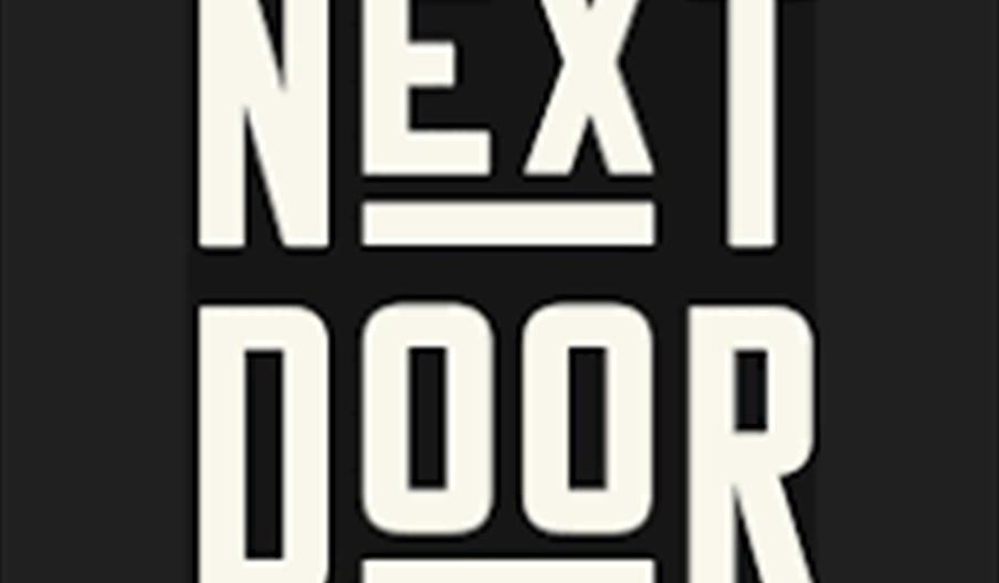 NEXT DOOR logo in bold white capital letters arranged in two stacked lines on a black background, with the words ‘NEXT’ above ‘DOOR’ and horizontal wh