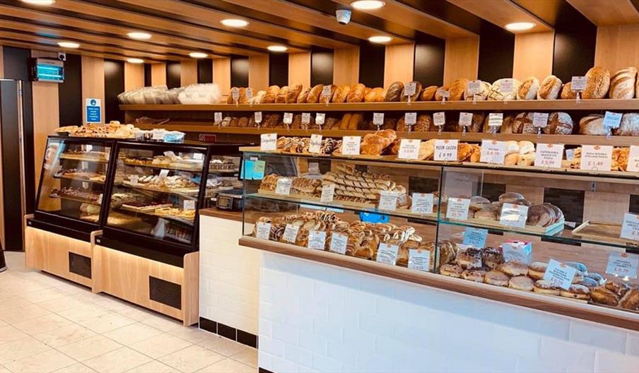 The inside of Karpaty bakery, with shelves and cabinets lined with loaves of bread and baked goods/pastries.