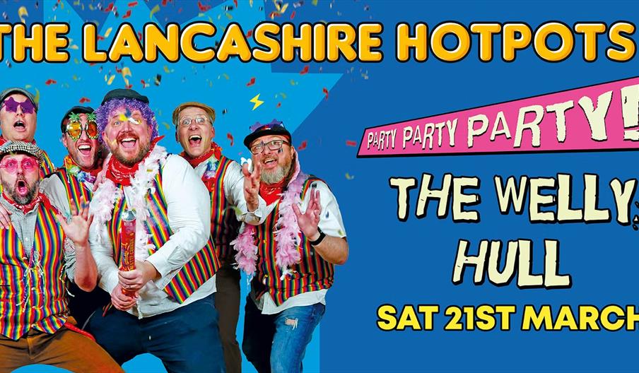 Promotional poster with six men in colorful, striped vests, festive accessories, and playful expressions, standing under confetti. Large text reads "T