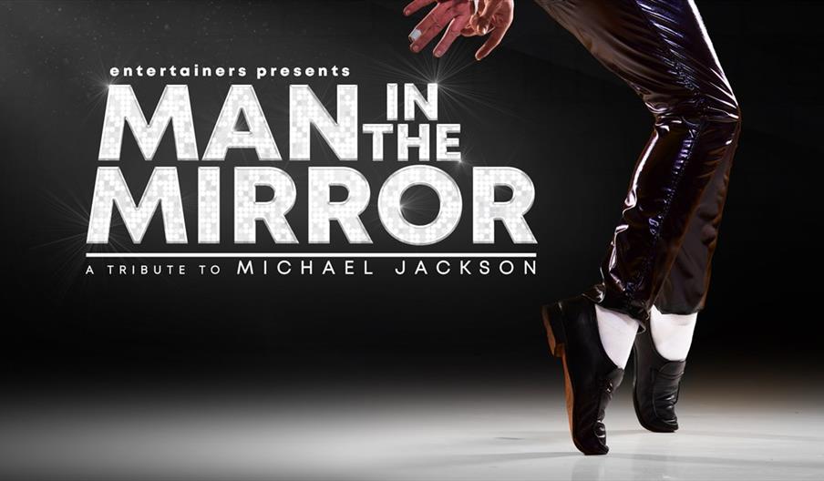 A pair of legs wearing black shoes, white socks and shiny black trousers poses next to a sparkling text that reads 'entertainers presents Man In The M