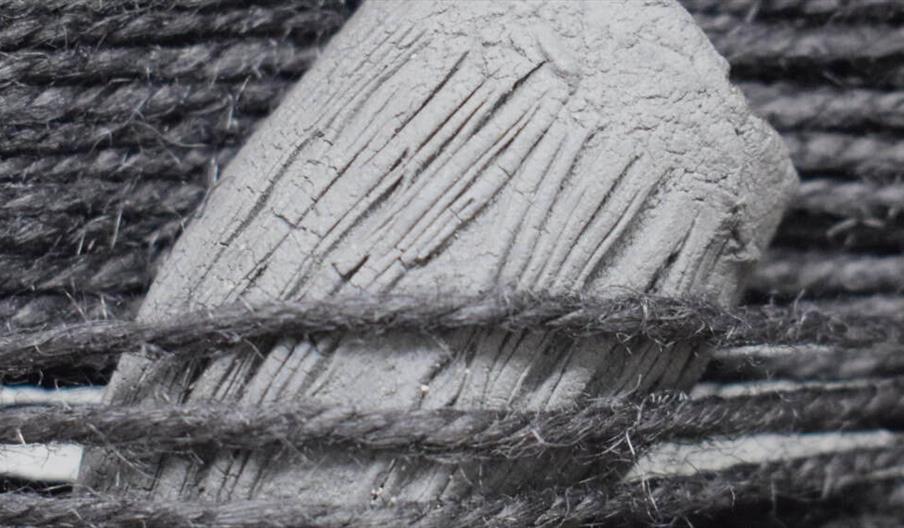 A closeup of yarn wrapped around a piece of wood.