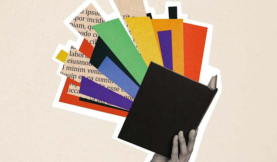A hand holding a closed black book with colorful, overlapping paper cutouts and printed text bursting out from behind it, creating a vibrant abstract