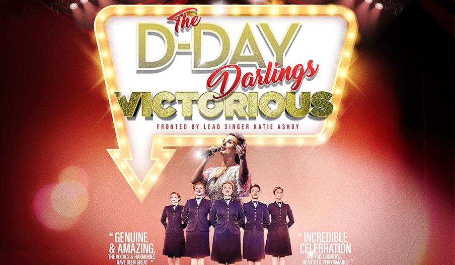 Promotional poster for "The D-Day Darlings: Victorious" show, featuring lead singer Katie Ashby singing into a microphone with a spotlight, seven wome