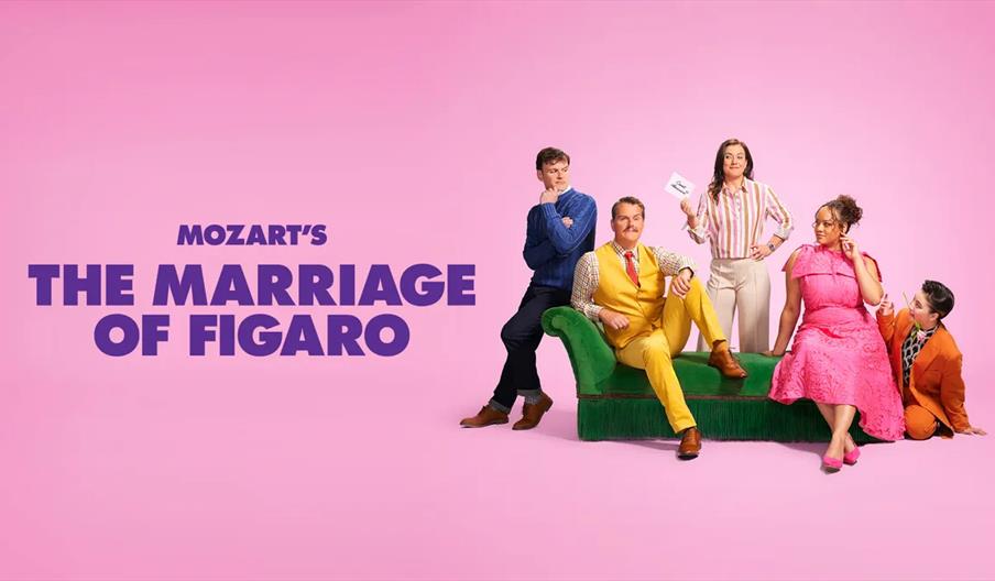 Five people in colourful, modern clothing pose on and around a green couch against a pink background, with large bold text on the left reading "Mozart