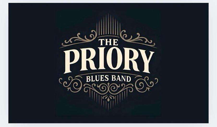 Logo for "The Priory Blues Band" in ornate cream-colored lettering on a dark background, featuring decorative flourishes above and below the band name