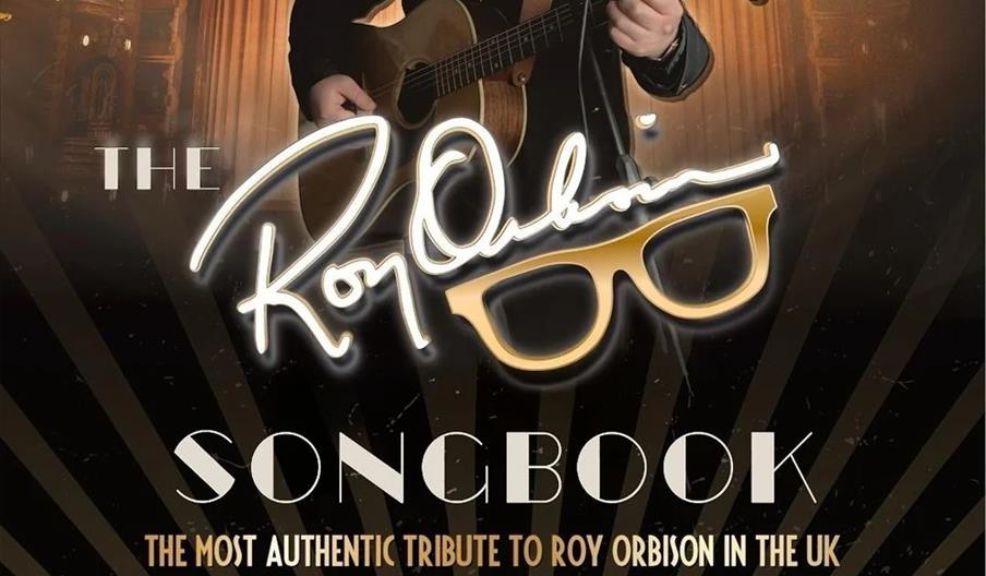 Poster for "The Roy Orbison Songbook," a UK tribute show featuring a man resembling Roy Orbison, wearing black sunglasses and holding a guitar on stag