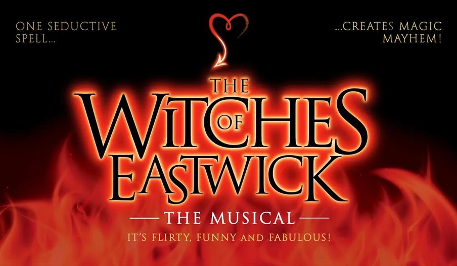 Poster for "The Witches of Eastwick: The Musical" featuring bold glowing letters surrounded by flames, a heart-shaped red line above the title, and th