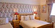 Double bedroom with wooden bed and floral accessories.