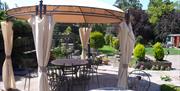 A  view of the garden in summmer with an ornamental metal gazebo, table and chairs at Acorn Guest House in Hull.