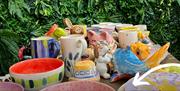 Display of colourful hand-painted pottery objects at Cozy Kiln studio in Hull.