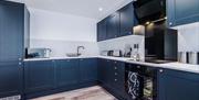 Navy kitchen with stainless steel appliances.